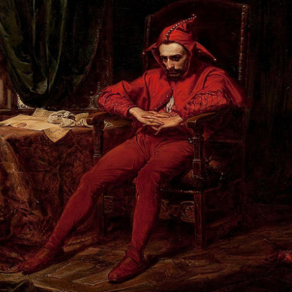 Man in a Jester Costume sitting in a chair as if he is plotting something