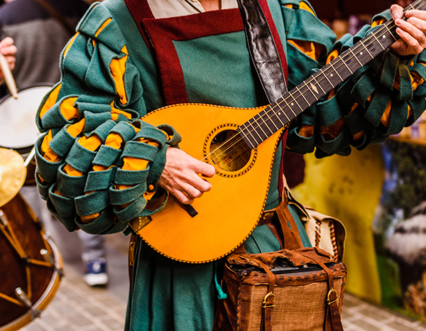 Valencia, Spain - January 27 , 2019: Medieval troubadour playing an antique guitar.