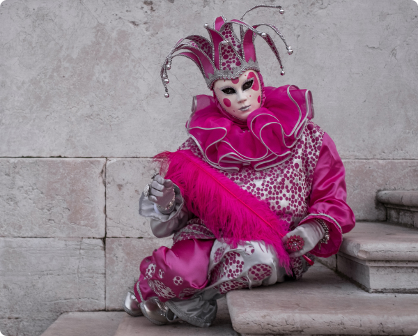jester in pink outfit sitting on stairs
