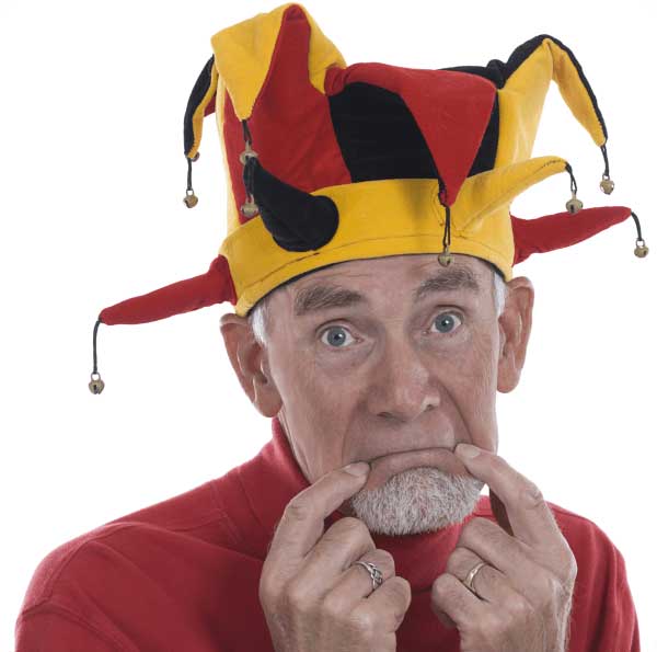 old man with jester hat on making a sad face