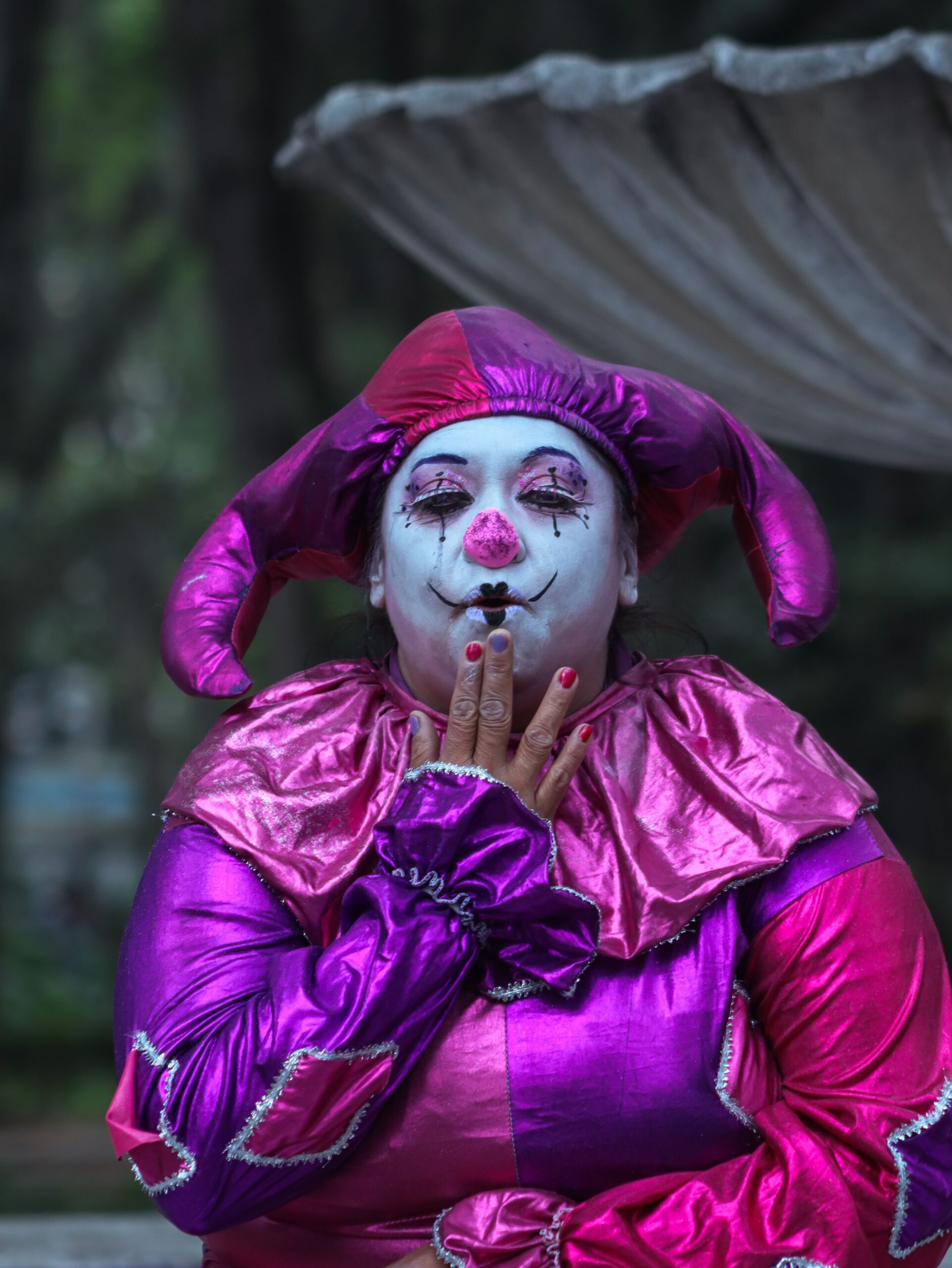 Person dressed as a colorful clown with a surprised expression